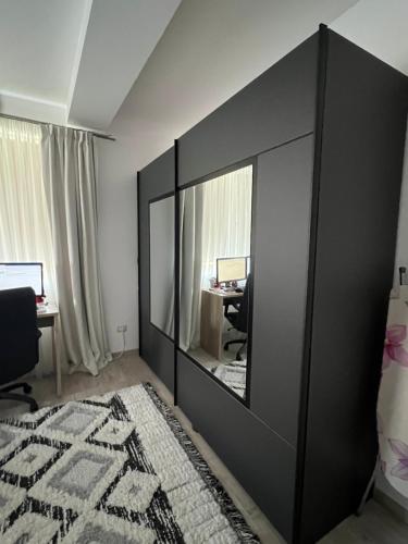 een grote zwarte spiegel in een kamer met een bureau bij Macilor Residence in Giroc