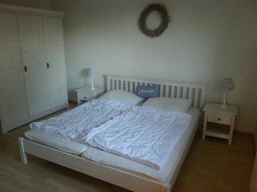 a bedroom with a white bed with two night stands at Haus Hygge - Ferienwohnung Hering in Boren