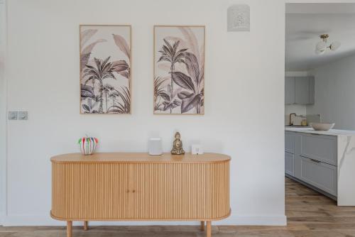 - un salon avec une table et deux photos sur le mur dans l'établissement Blue Villa near Disneyland Paris, à Chalifert