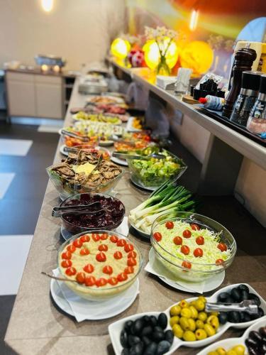 a buffet line with many different types of pizzas and vegetables at Hotel Eden Garden Spa in Câmpulung Moldovenesc
