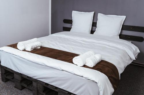 a large bed with white sheets and pillows at Casa Rosu in Cluj-Napoca