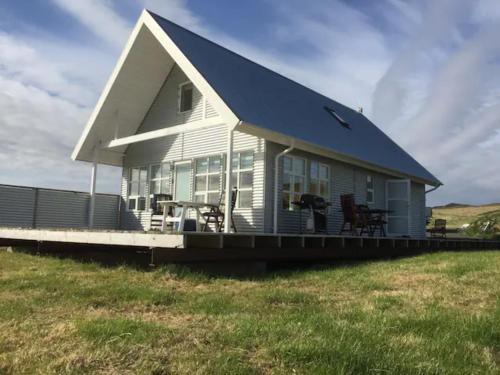 una casa con techo azul en un campo en Efri Foss, en Staður