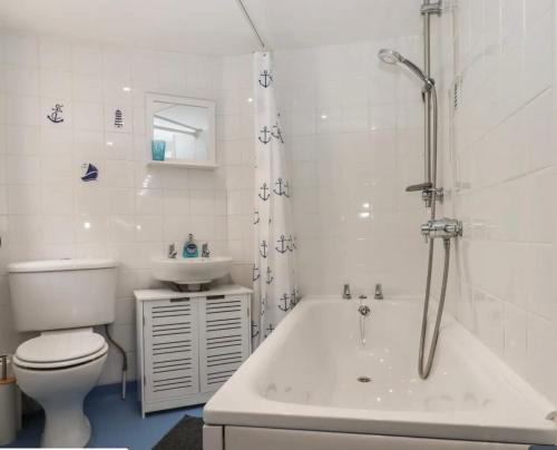 La salle de bains est pourvue de toilettes, d'une baignoire et d'un lavabo. dans l'établissement Stokeinteignhead, South Devon, Character Countryside Apartment, à Stokeinteignhead