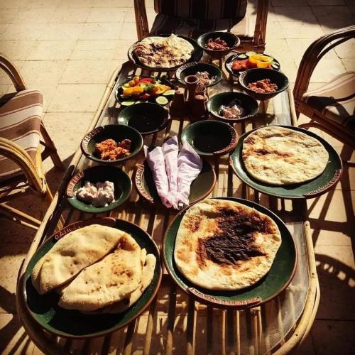 a table with many plates of food on it at Qasr El Bagawat Hotel in ‘Ezbet Halfa
