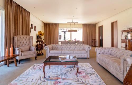 uma sala de estar com dois sofás e uma mesa em The Woods Worth Villa em Vani