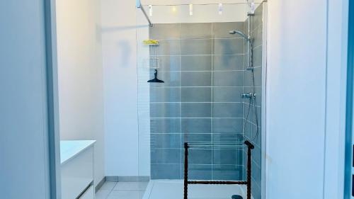 une salle de bain avec douche aux carreaux bleus dans l'établissement Baie Dream appartement en front de mer, à Cayeux-sur-Mer