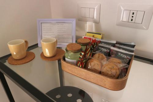 - un bureau avec un plateau de viennoiseries et 2 tasses dans l'établissement Il Sogno del Lago, à Anguillara Sabazia