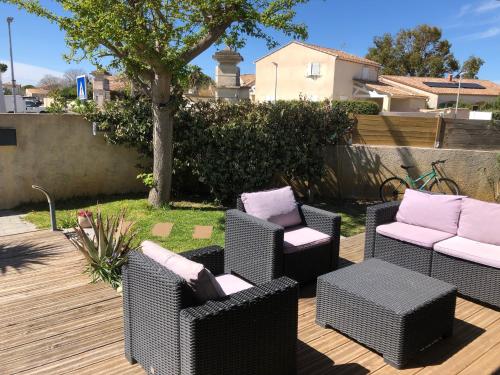 une terrasse avec 2 chaises, une table et un arbre dans l'établissement Chambre dans belle maison à Lattes, à Lattes
