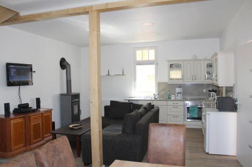 ein Wohnzimmer mit einem Sofa und einer Küche in der Unterkunft Ferienhaus "Waldidyll Brunni" in Marlow