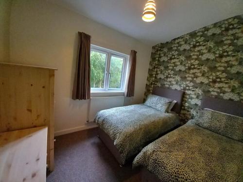a bedroom with two beds and a window at Chapter Farm Cottages in Canterbury