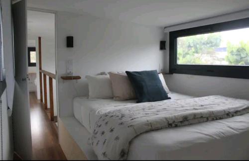 um quarto com uma cama grande e uma janela em Fantástica Tiny House De luxe em Canet de Mar