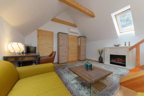 a living room with a yellow couch and a fireplace at Hiša Ojstrica in Solčava