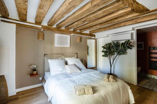 une chambre avec un grand lit avec deux serviettes dessus dans l'établissement Le nid, à Paris