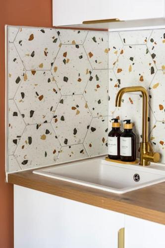 un évier de cuisine avec deux bouteilles d'huiles essentielles dessus dans l'établissement Le nid, à Paris