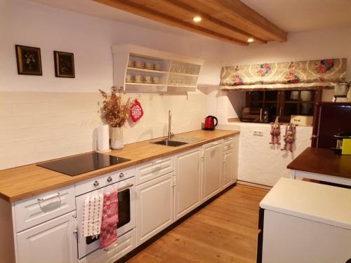 a kitchen with white cabinets and a counter top at Landhaus Schusterfranz in Passail