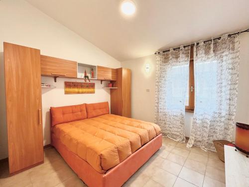 a bedroom with an orange bed in a room at alloggio turistico Viaggiattori - lago di Bolsena in Valentano
