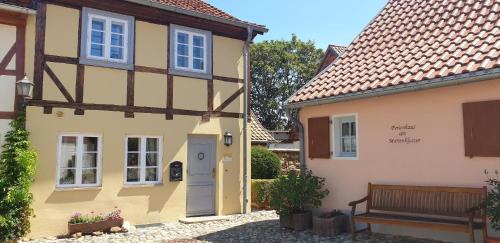a yellow house with a blue door and a bench at Romantisches Ferienhaus für 8 Personen in Quedlinburg