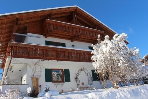 una casa en invierno con nieve en el suelo en Panoramaausblick auf Berge, See und Ort in ruhiger Lage en Lechbruck