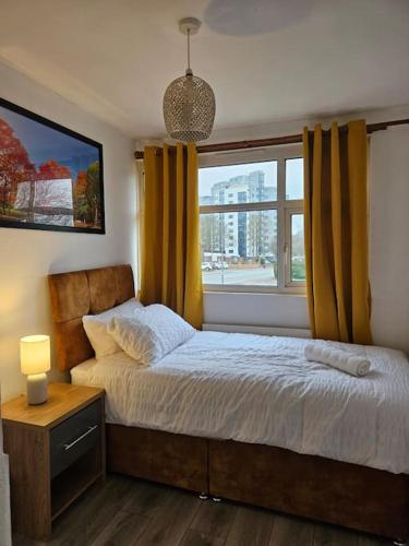 1 dormitorio con 1 cama con cortinas amarillas y ventana en City Classic, en Birmingham