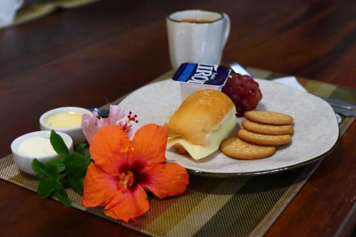 um prato de comida com biscoitos de queijo e uma flor vermelha em Lampião Hostel em Florianópolis