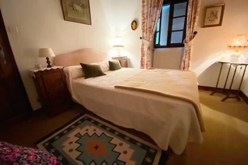 une chambre avec un lit avec des draps blancs et une fenêtre dans l'établissement Maison avec piscine - Juvinas, à Juvinas