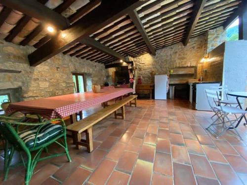 une salle à manger avec une table et une cuisine dans l'établissement Maison avec piscine - Juvinas, à Juvinas