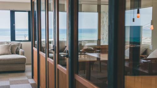 a living room with a couch and a table and chairs at Blue Steak Wonder Nagahama in Yomitan