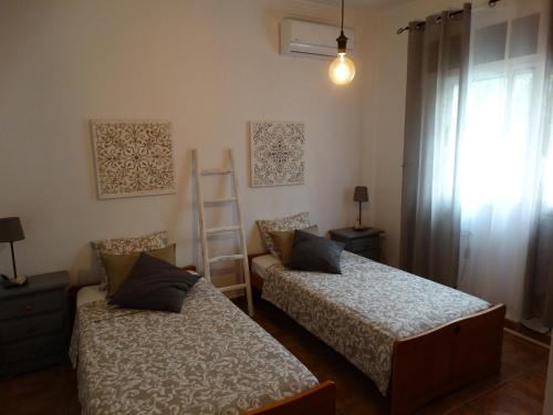 um quarto com 2 camas, uma escada e uma janela em Villa Las Campanas em Periana