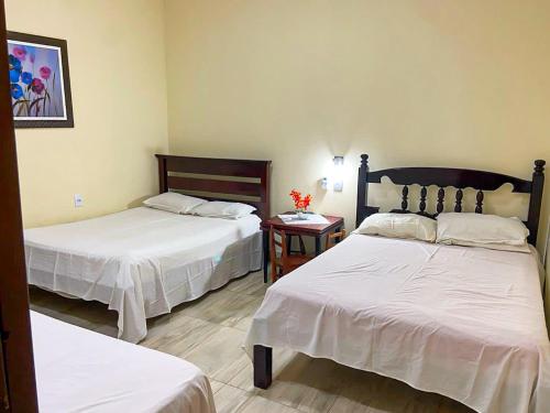 a hotel room with two beds and a table at Paraíso Panorâmico Beira do Lago in Caldas Novas