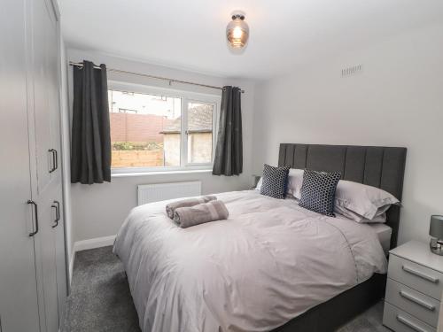 a bedroom with a large bed with a window at 12 Merefell Road in Carnforth