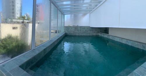 a swimming pool in a building with blue water at Hotel Sibara SPA & Convenções in Balneário Camboriú