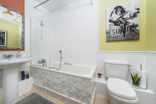 a bathroom with a tub and a toilet and a sink at St George Wharf in London