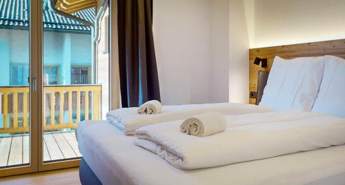 2 bedden in een hotelkamer met een balkon bij Garmisch Chalets - Wohnung Pflegersee in Garmisch-Partenkirchen