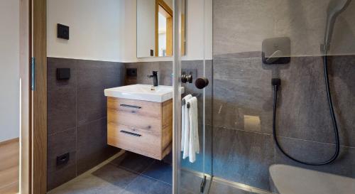 ein Bad mit einem Waschbecken und einer Dusche in der Unterkunft Garmisch Chalets - Wohnung Pflegersee in Garmisch-Partenkirchen