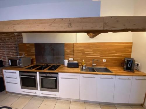 a kitchen with a stove and a sink in it at Chez Victor H in Amiens