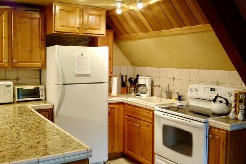 una cucina con frigorifero bianco e armadietti in legno di Historic Big Mountain Chalet Upper a Whitefish