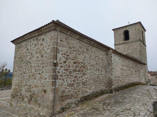 an old stone building with a bell tower at Alojamientos La Dehesa in El Berrueco