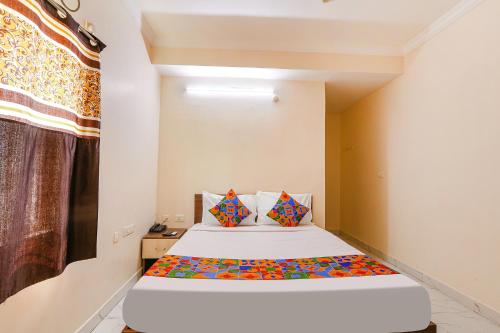 a bedroom with a bed and a window at FabHotel Opal Residency in Hyderabad