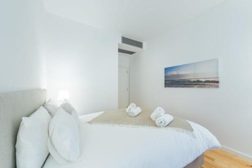 Un dormitorio blanco con una cama con toallas. en GuestReady - São Domingos - The Cathedral en Oporto