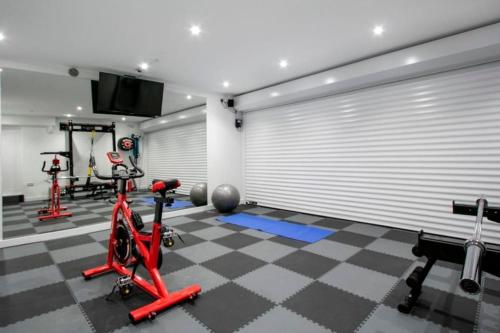 a gym with two exercise bikes and a television in it at BOURNECOAST: *HOT TUB*BBQ HUT*GYM*GARDEN* HB6340 in Bournemouth