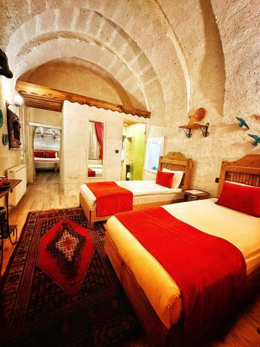a bedroom with two beds in a stone room at Sakli Cave House in Avanos
