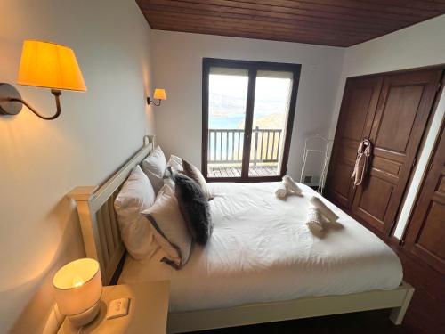 une chambre avec un grand lit avec une fenêtre dans l'établissement La Closette, à Rovagny