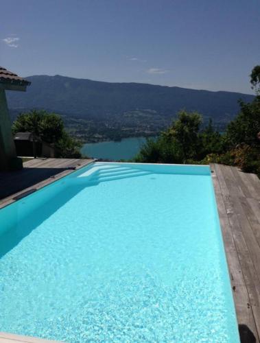 - une piscine bleue avec vue sur le lac dans l'établissement La Closette, à Rovagny