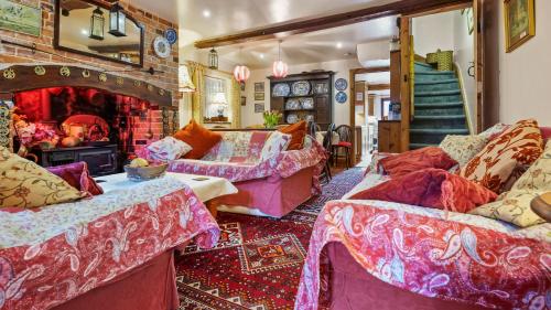 a living room with two beds and a fireplace at The Coach House in Wareham