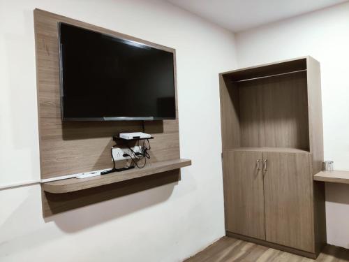 a room with a flat screen tv and a bike on a wall at HOTEL NEW RATNAKAR in Daman