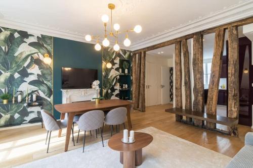 une salle à manger avec une table, des chaises et un canapé dans l'établissement Appart 8pers#Rivoli#Samaritaine#Pont Neuf, à Paris