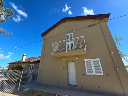 Cette maison dispose d'une porte blanche et d'un balcon. dans l'établissement Tre Lati b&b, à Case del Bevano