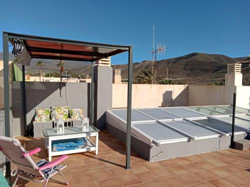 a bed and a chair on a roof at Christian in Cruce de Arinaga