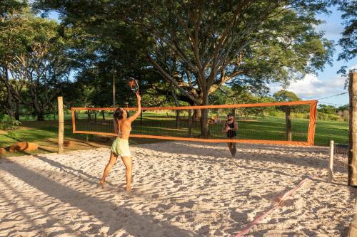 a woman is playing volleyball on a beach at Pousada Rio Gouveia in Brotas
