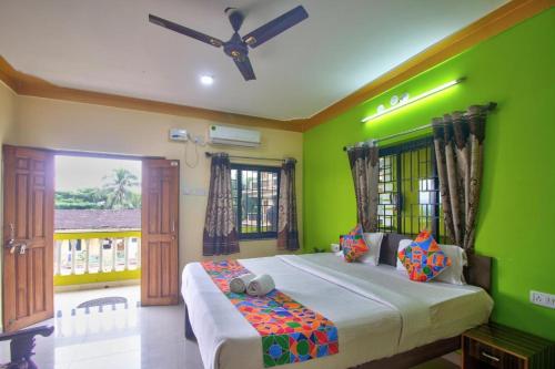 ein Schlafzimmer mit einem großen Bett mit grünen Wänden in der Unterkunft The Baga beach 24in in Calangute